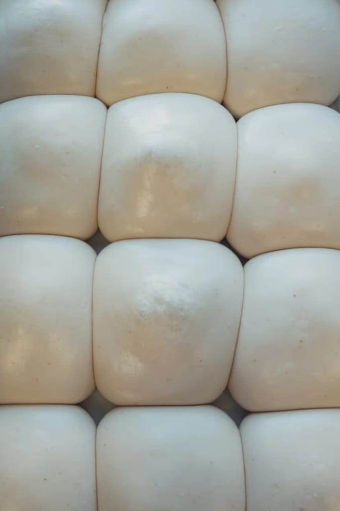 Balls of sourdough pizza dough proofing in a tray