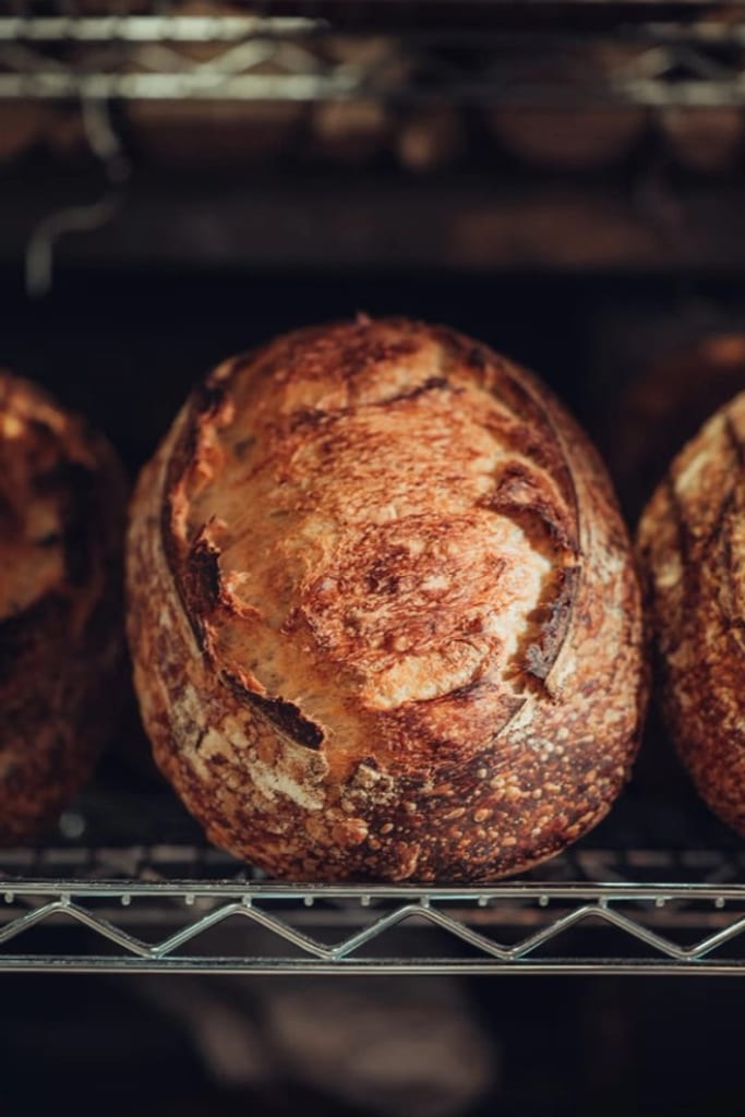 A naturally fermented sourdough loaf on a cooling rack