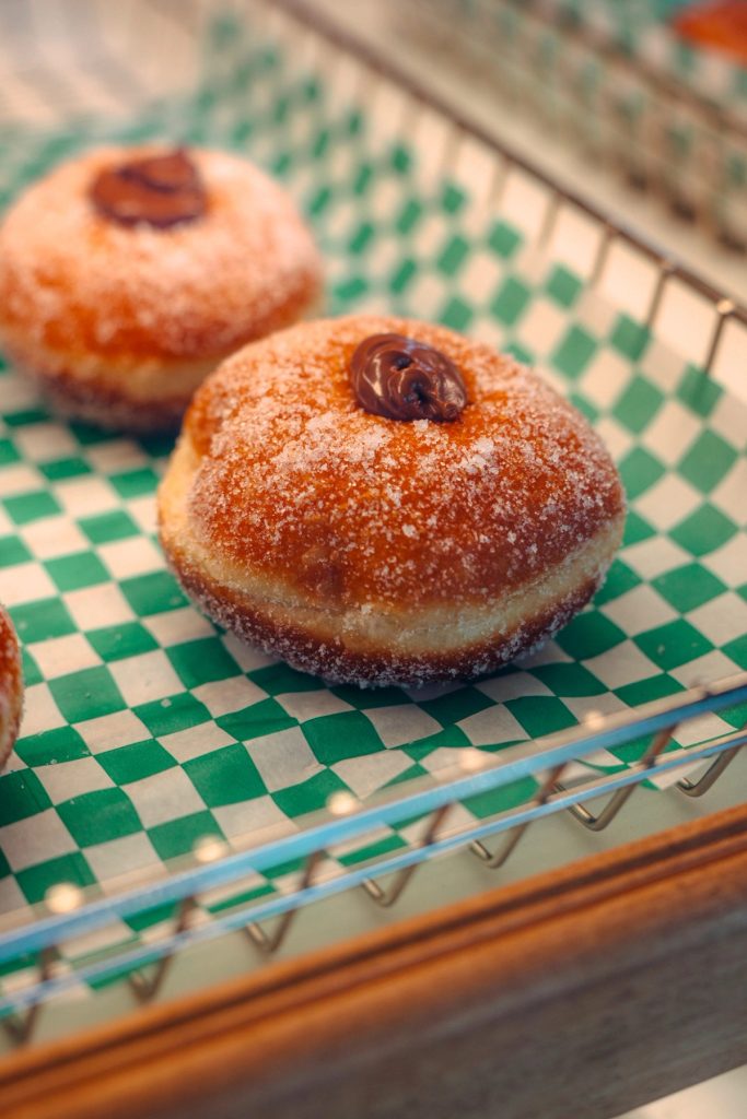 Sugar-dusted Nutella Bombe on checkered paper in the pastry case