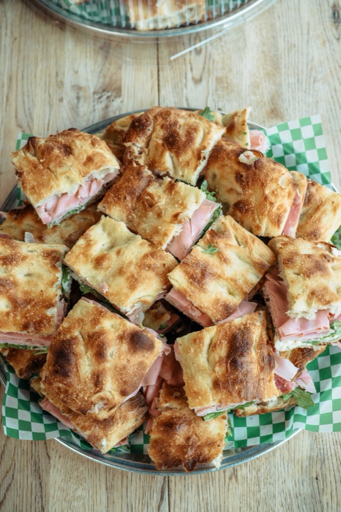 A catering platter of focaccia sandwiches cut in four