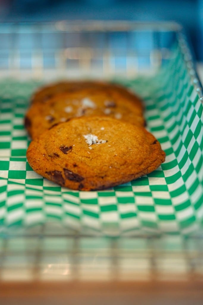 Dark chocolate sea salt cookies on checkered paper in the pastry case
