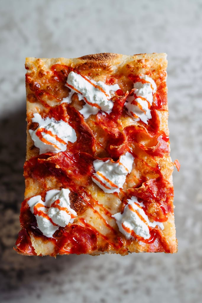 Bee Sting sourdough pizza slice with hot soppressata, stracciatella and hot honey