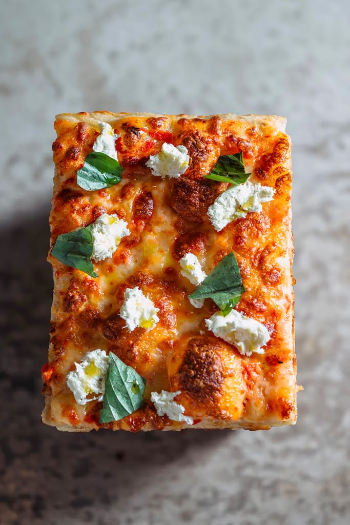 Margherita sourdough pizza slice with fior di latte and fresh basil