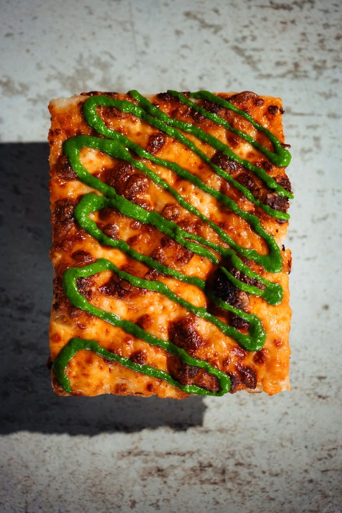 Vodka sourdough pizza slice with mozzarella and a basil drizzle