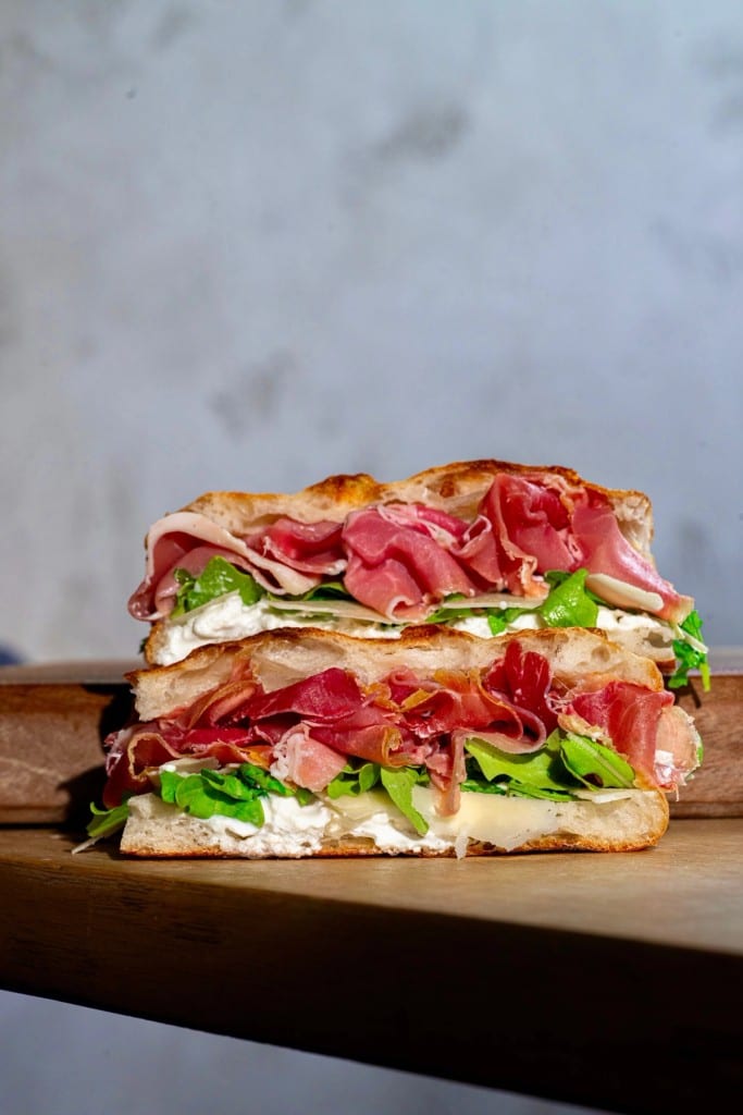 Classico prosciutto focaccia sandwich with stracciatella, arugula and shaved parmigiano